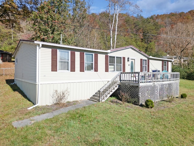 manufactured / mobile home featuring a front yard and a deck