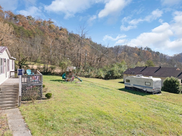 view of yard featuring a deck and a playground