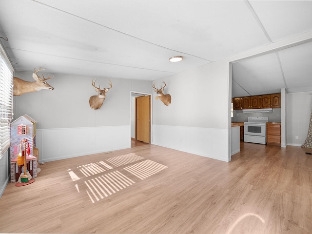 unfurnished living room with light hardwood / wood-style floors and lofted ceiling