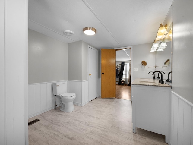 bathroom with toilet, vanity, and hardwood / wood-style floors