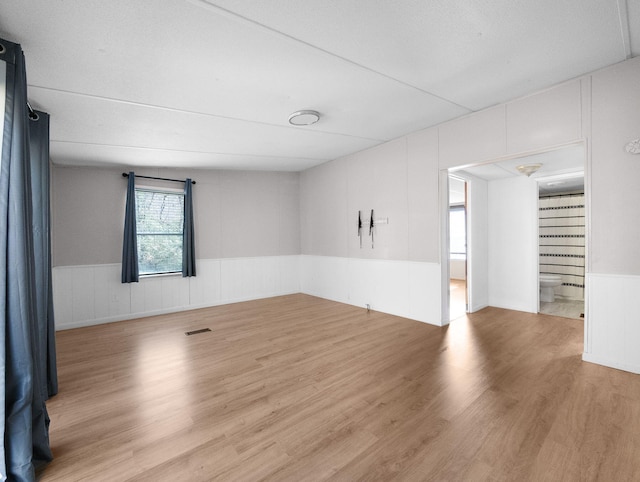 spare room featuring light hardwood / wood-style floors and a textured ceiling