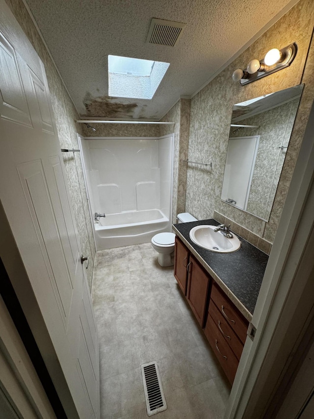 full bathroom with a textured ceiling, vanity, shower / washtub combination, and a skylight