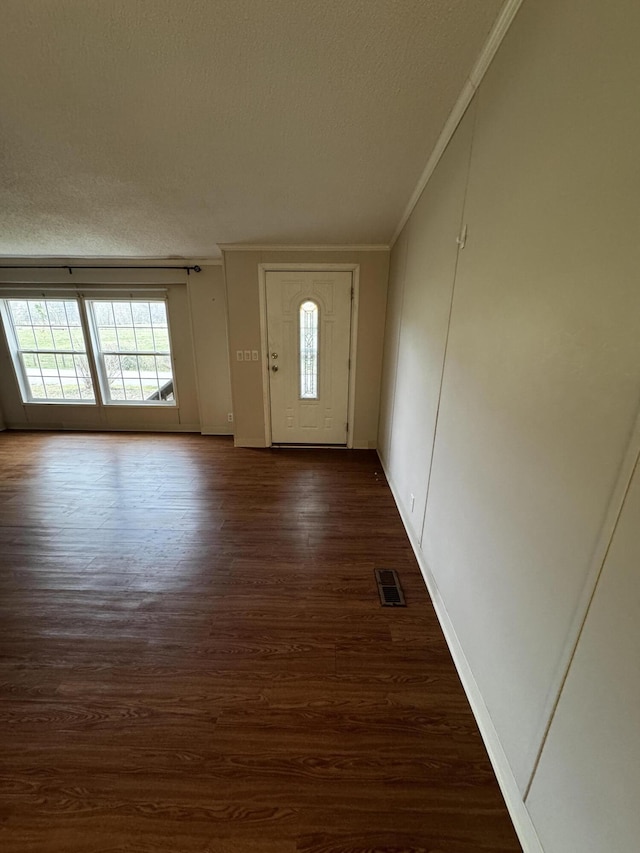 entrance foyer with dark hardwood / wood-style floors, crown molding, and a textured ceiling