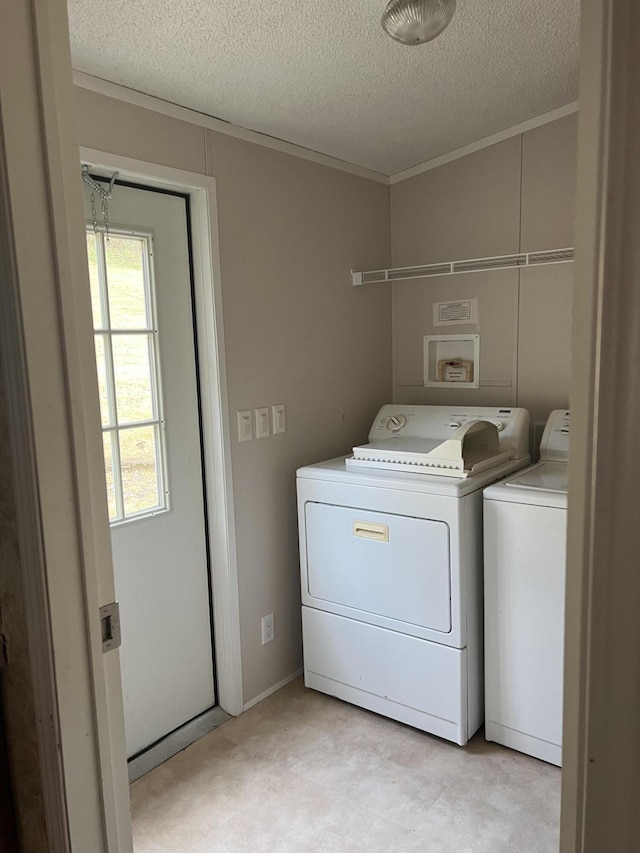 laundry area with washer and dryer, a textured ceiling, and crown molding