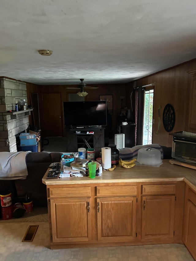 kitchen featuring tasteful backsplash, ceiling fan, and a fireplace