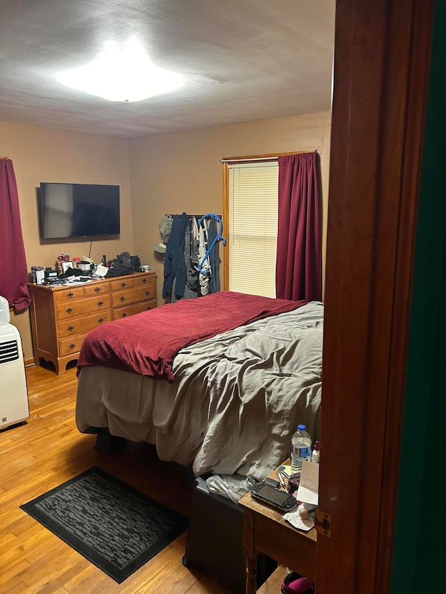 bedroom featuring light hardwood / wood-style flooring and a textured ceiling