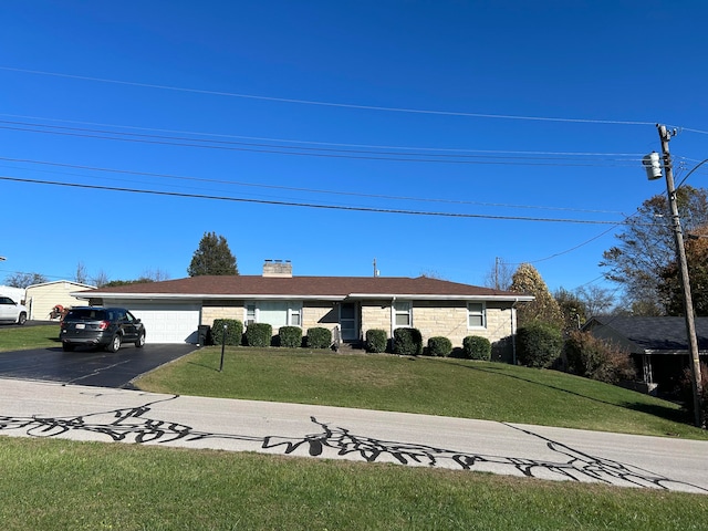 ranch-style home featuring a front lawn and a garage