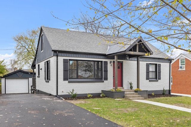 bungalow-style house with an outbuilding, a front lawn, and a garage