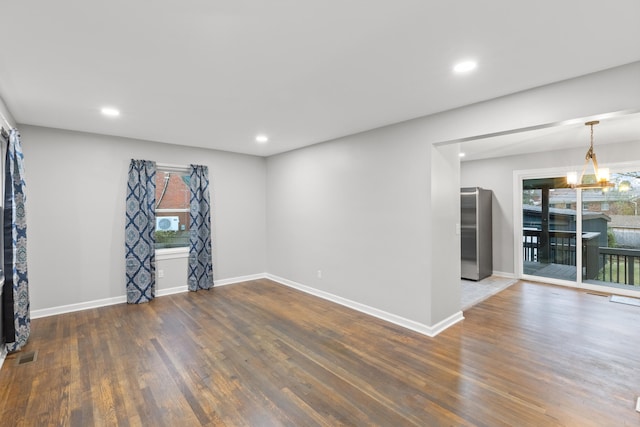 unfurnished room with dark hardwood / wood-style flooring and a notable chandelier