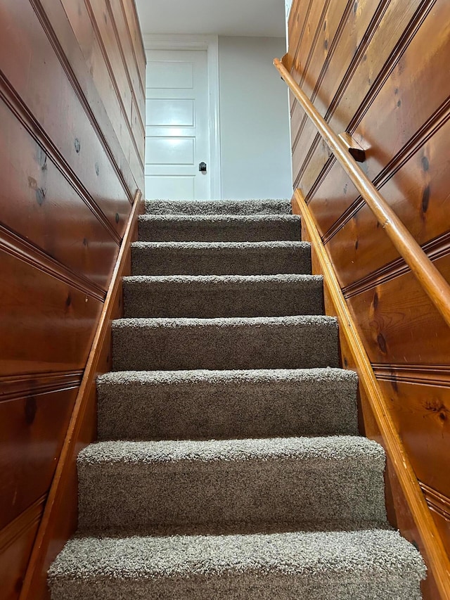 staircase with wood walls