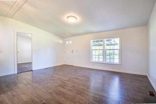 spare room with lofted ceiling, a textured ceiling, and dark hardwood / wood-style floors