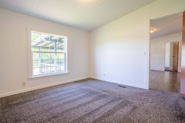 spare room with hardwood / wood-style floors and vaulted ceiling