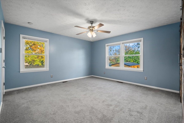 carpeted empty room with a textured ceiling and ceiling fan