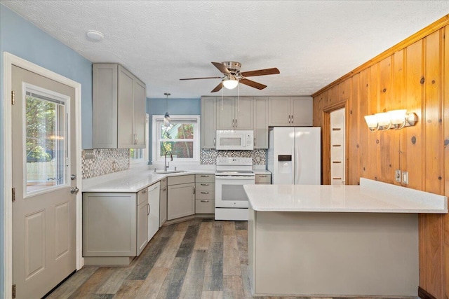 kitchen with gray cabinets, sink, white appliances, and kitchen peninsula