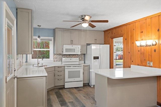 kitchen with sink, gray cabinets, dark hardwood / wood-style floors, white appliances, and decorative light fixtures