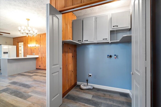 washroom featuring hookup for a washing machine, electric dryer hookup, dark wood-type flooring, and ceiling fan with notable chandelier