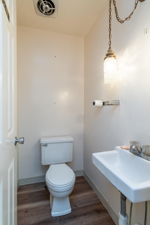 bathroom featuring hardwood / wood-style floors and toilet