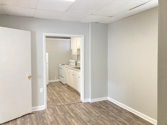 hallway featuring a drop ceiling and dark wood-type flooring