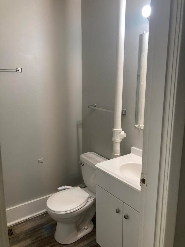 bathroom featuring toilet, vanity, and hardwood / wood-style flooring