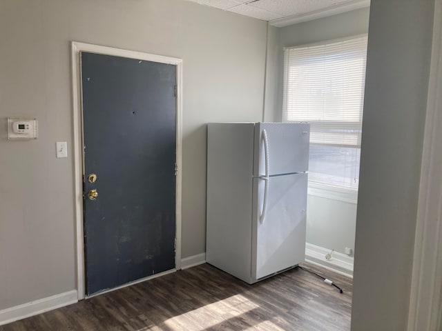 kitchen featuring white fridge and dark wood-type flooring