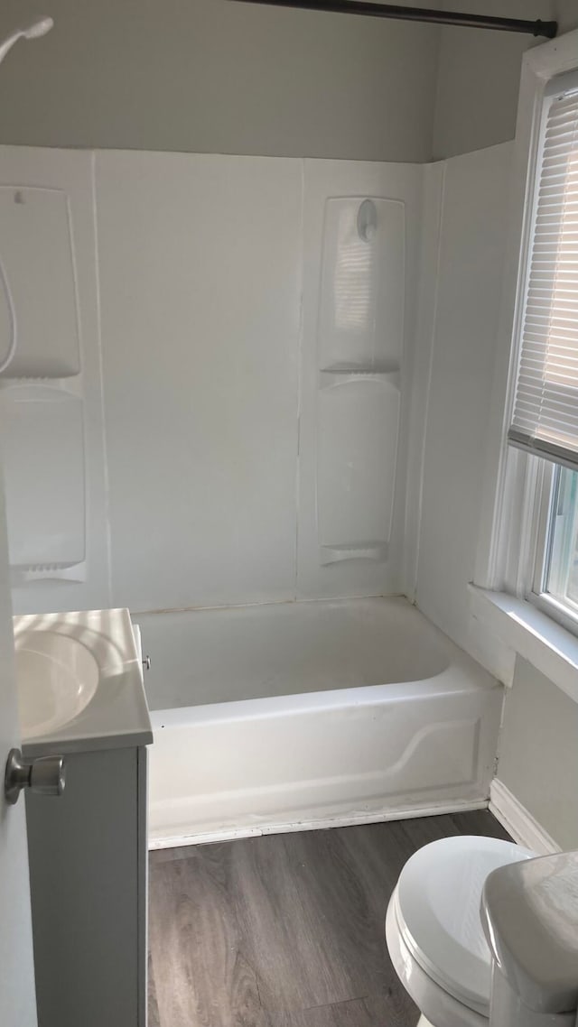 full bathroom with vanity, toilet, hardwood / wood-style flooring, and bathtub / shower combination