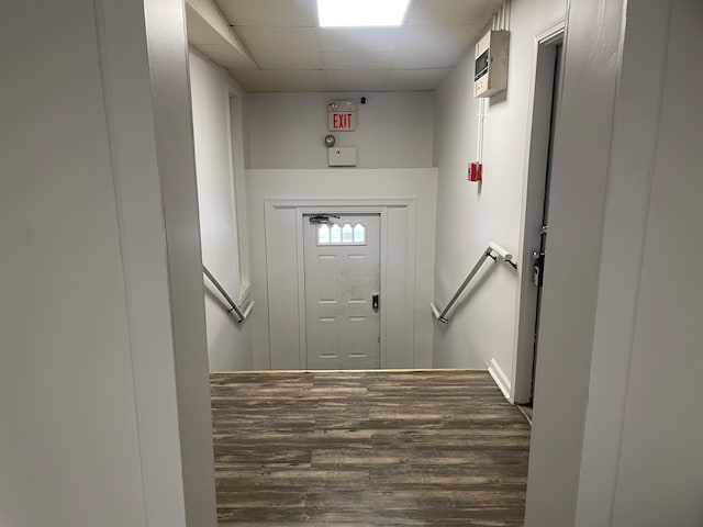 doorway with a paneled ceiling and dark hardwood / wood-style flooring