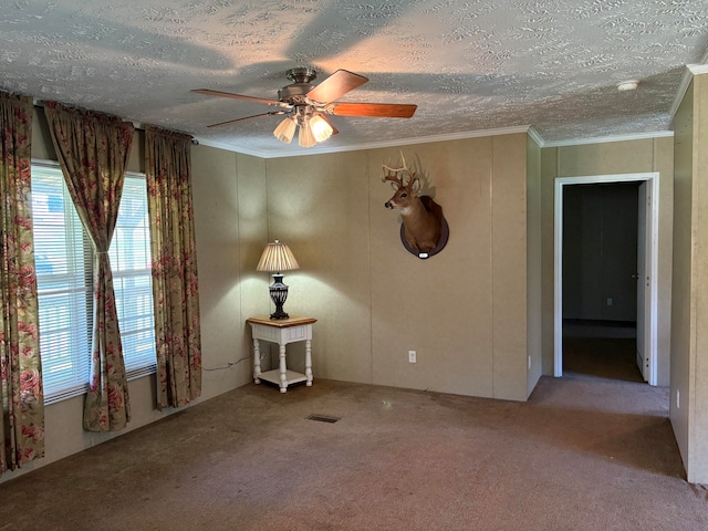 spare room with ceiling fan, light colored carpet, a textured ceiling, and crown molding