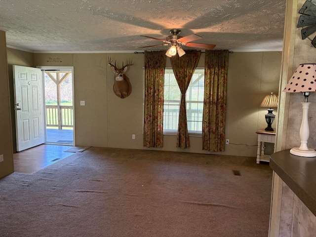 unfurnished living room featuring a textured ceiling, carpet floors, and ceiling fan