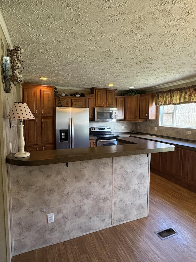 580 Bales Creek Rd, Manchester, KY 40962 - kitchen featuring stainless steel appliances, dark countertops, wood finished floors, and brown cabinets