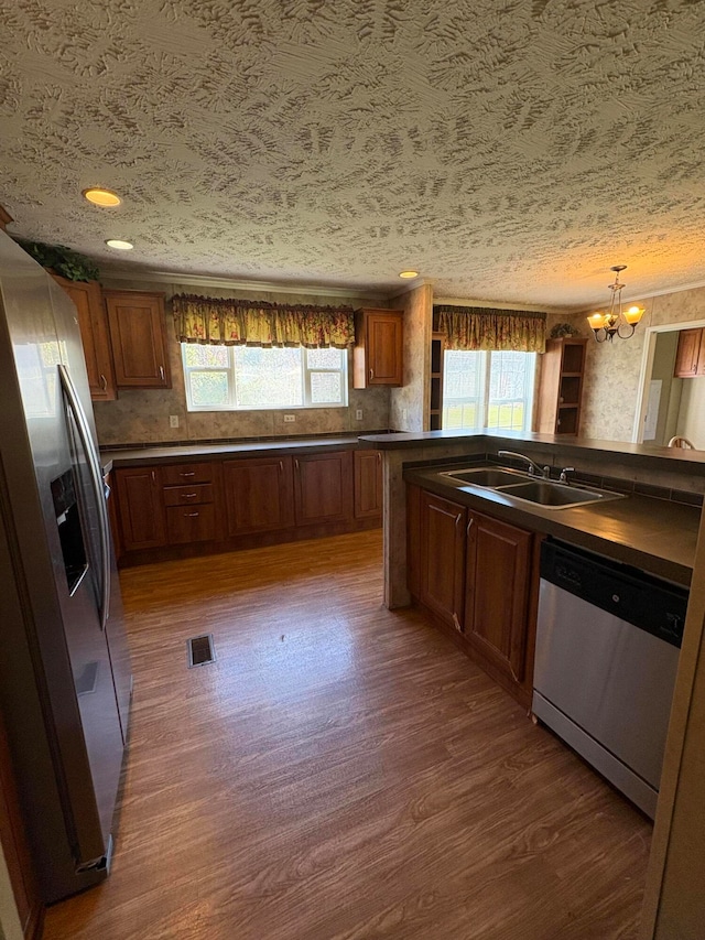 kitchen featuring stainless steel appliances, sink, tasteful backsplash, dark hardwood / wood-style floors, and decorative light fixtures