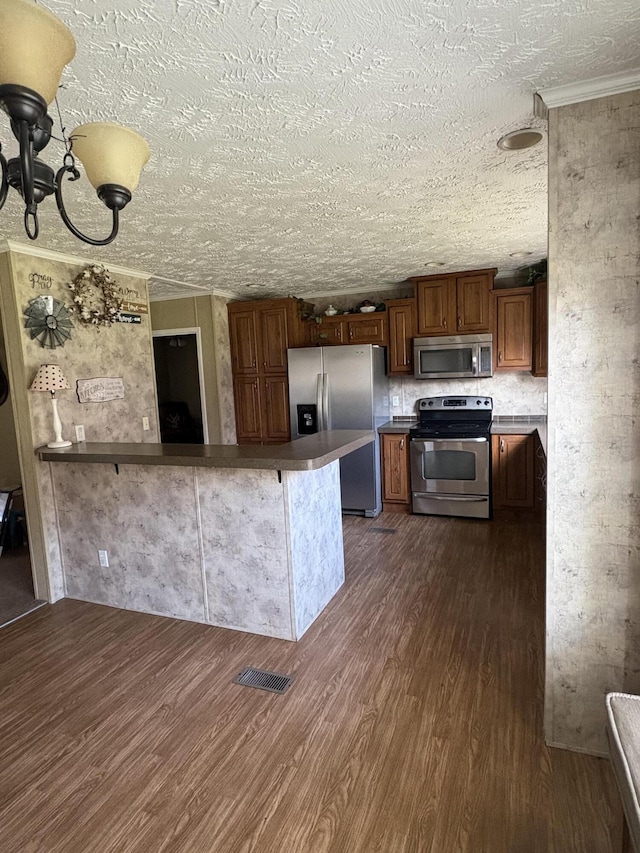 580 Bales Creek Rd, Manchester, KY 40962 - kitchen featuring stainless steel appliances, dark wood finished floors, a textured ceiling, a peninsula, and a chandelier