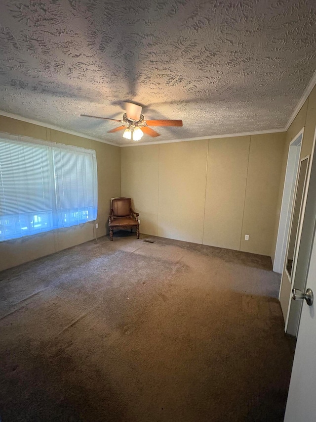 carpeted empty room with crown molding, a textured ceiling, and ceiling fan