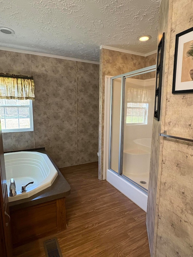 bathroom with wood-type flooring, vaulted ceiling, a textured ceiling, plus walk in shower, and crown molding