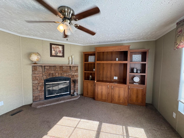 unfurnished living room with ceiling fan, a textured ceiling, a fireplace, crown molding, and light colored carpet