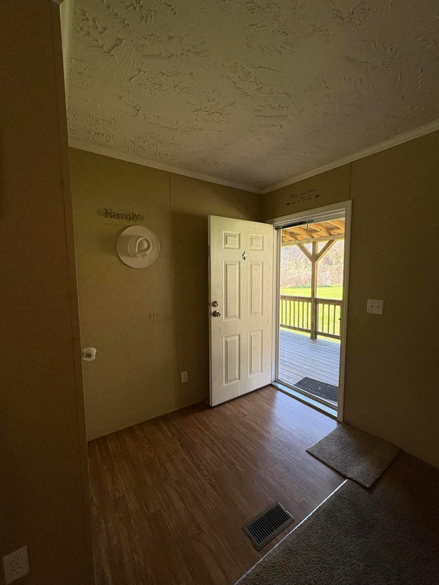 foyer with dark hardwood / wood-style flooring, a textured ceiling, and ornamental molding