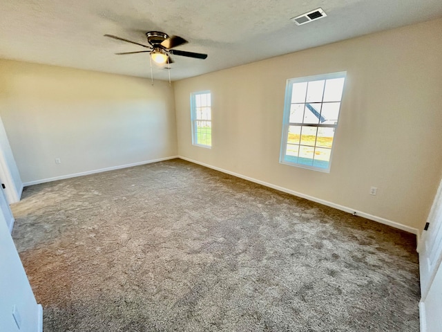 carpeted empty room featuring a textured ceiling and ceiling fan