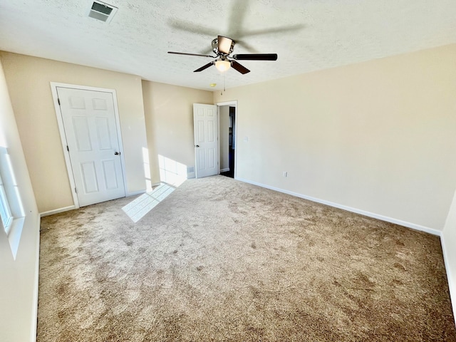 unfurnished bedroom featuring carpet flooring, a textured ceiling, and ceiling fan