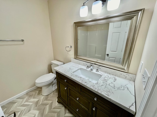 bathroom featuring toilet, vanity, parquet flooring, and walk in shower