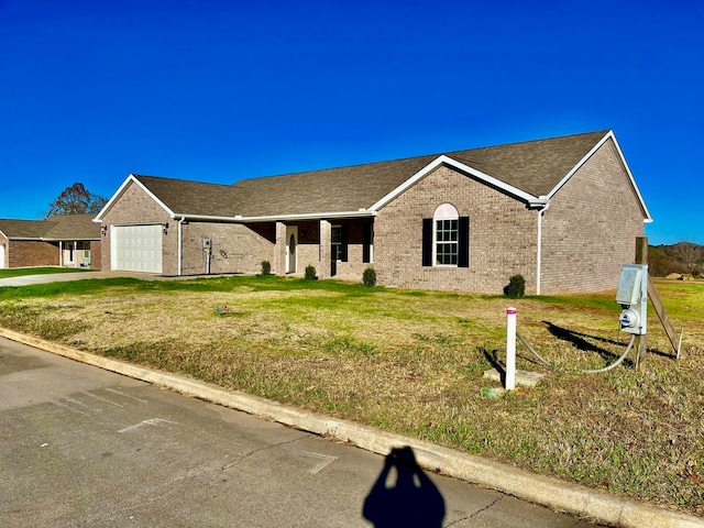 ranch-style home featuring a front lawn and a garage