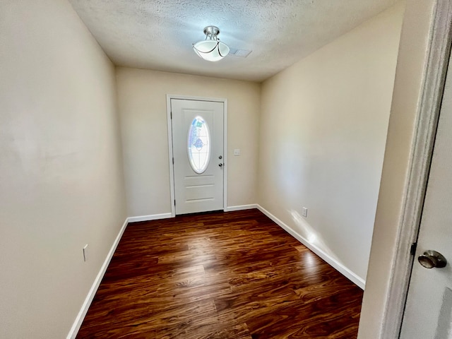 entryway with dark hardwood / wood-style flooring and a textured ceiling