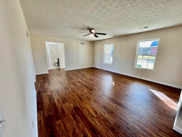 spare room with ceiling fan, dark hardwood / wood-style floors, and a textured ceiling