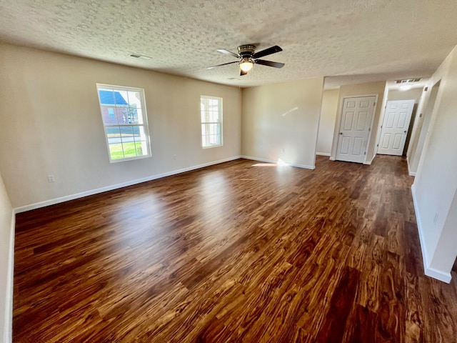 unfurnished room featuring ceiling fan, dark hardwood / wood-style floors, and a textured ceiling