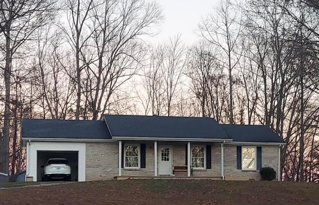 ranch-style house featuring a garage and covered porch