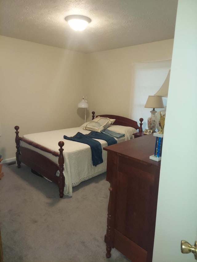 bedroom featuring carpet and a textured ceiling