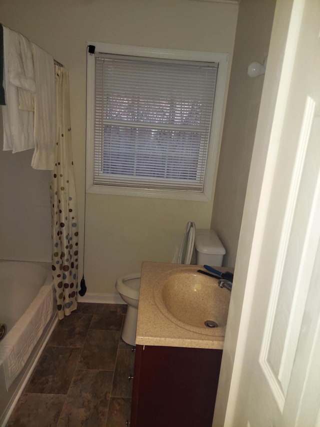 full bathroom featuring vanity, shower / bath combo with shower curtain, and toilet