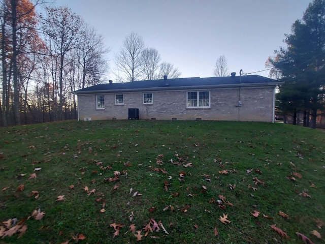 back of house featuring a lawn and cooling unit