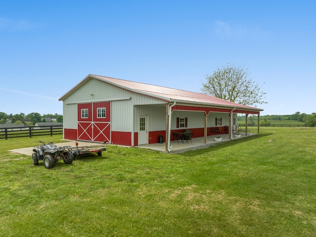 view of outbuilding featuring a lawn and a rural view