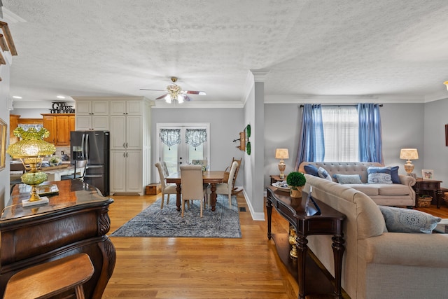 living room featuring ceiling fan, crown molding, light hardwood / wood-style floors, and plenty of natural light