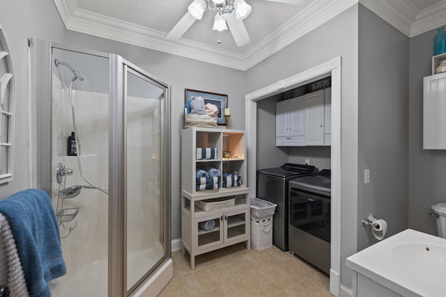 bathroom with ornamental molding, ceiling fan, an enclosed shower, and separate washer and dryer