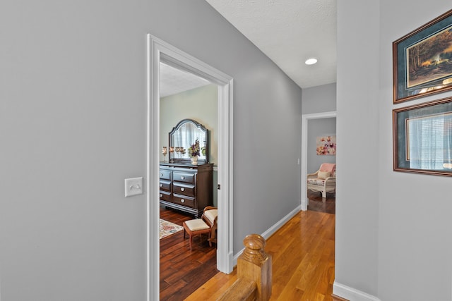 hallway featuring a textured ceiling and light hardwood / wood-style flooring